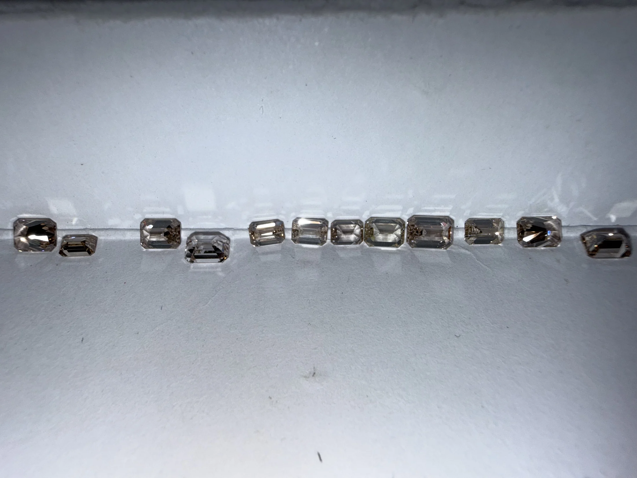 A row of emerald cut diamonds ready for shipment