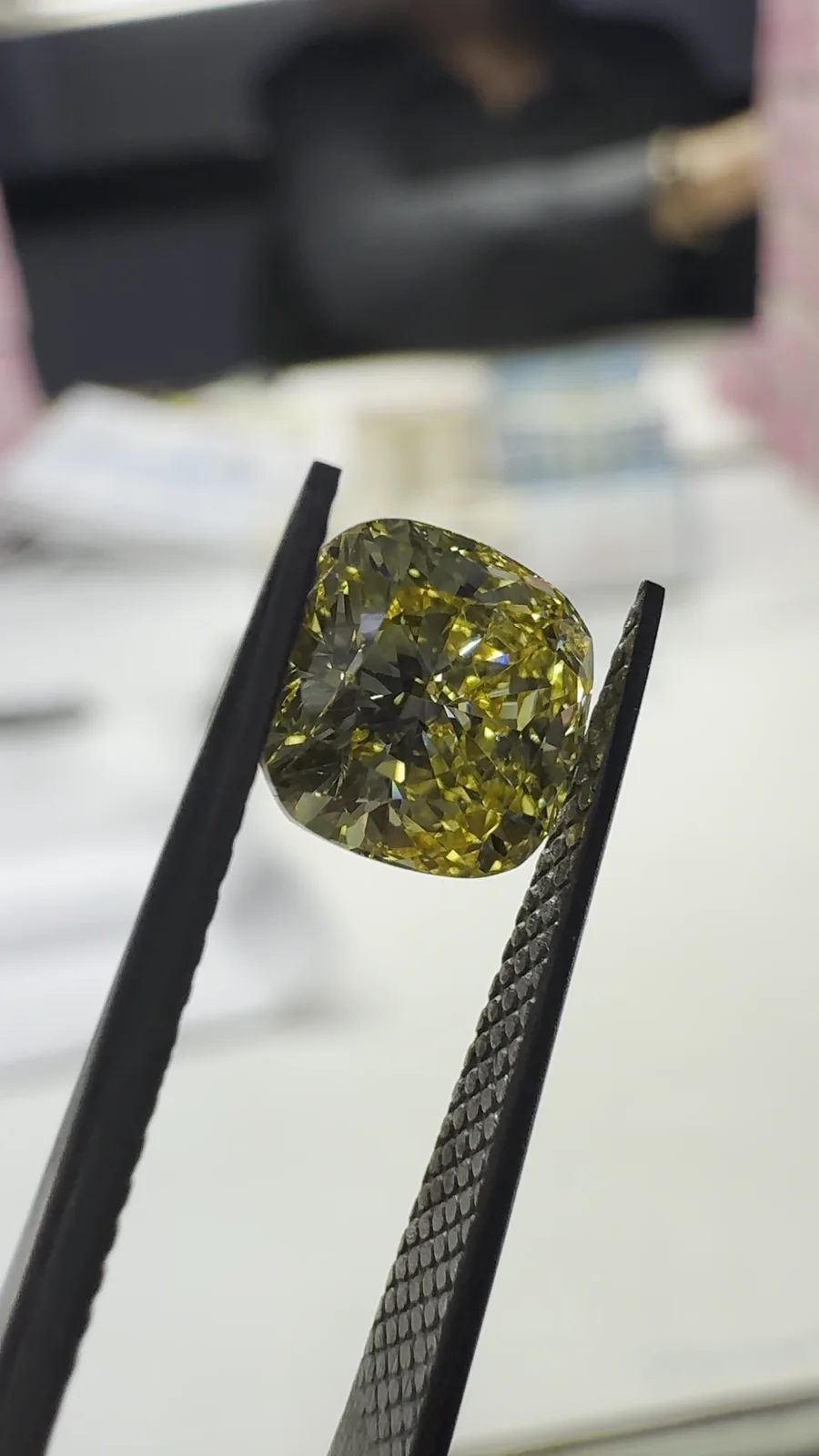 A yellow cushion cut diamond under daylight