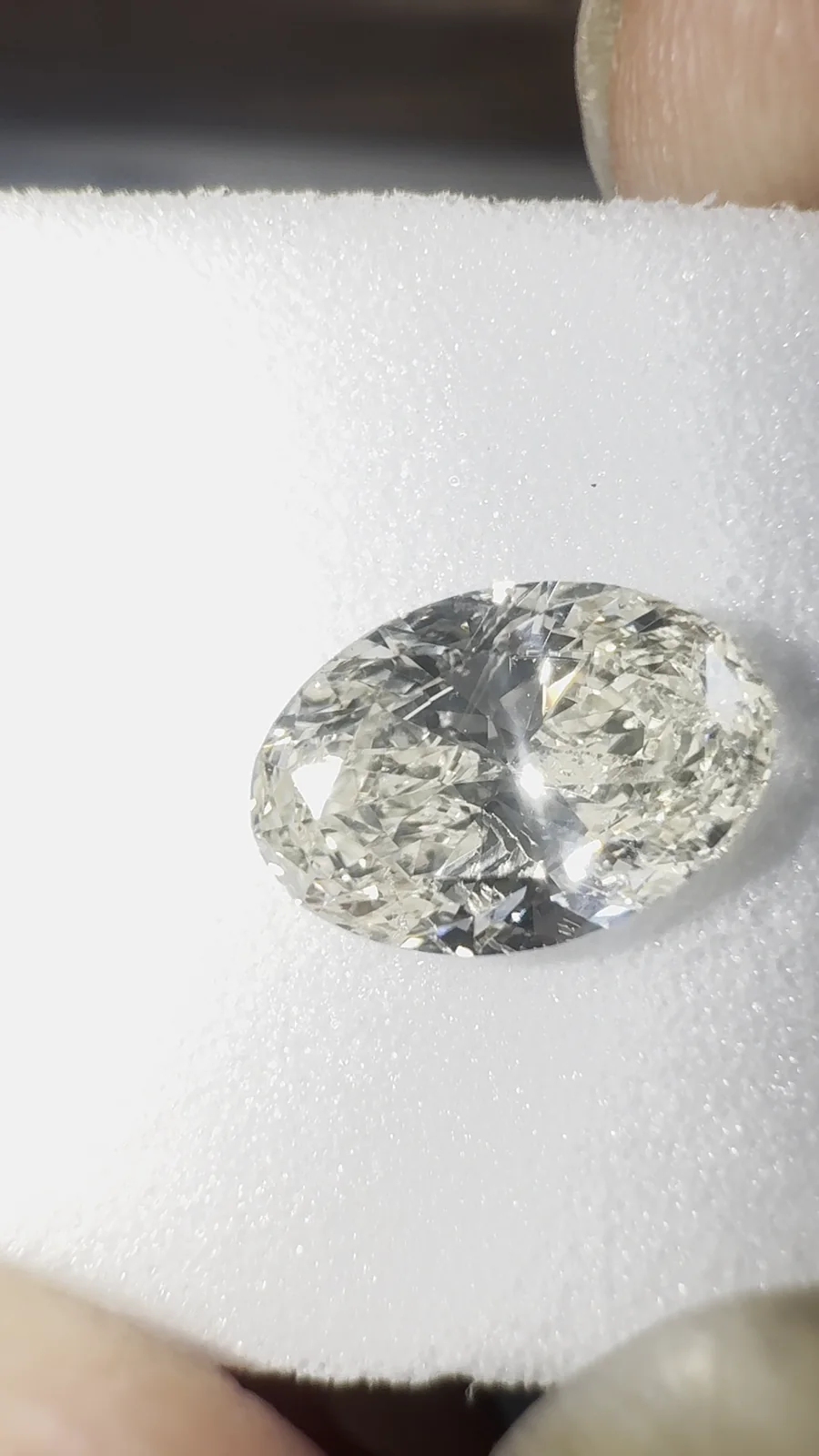 An oval diamond on its grading card