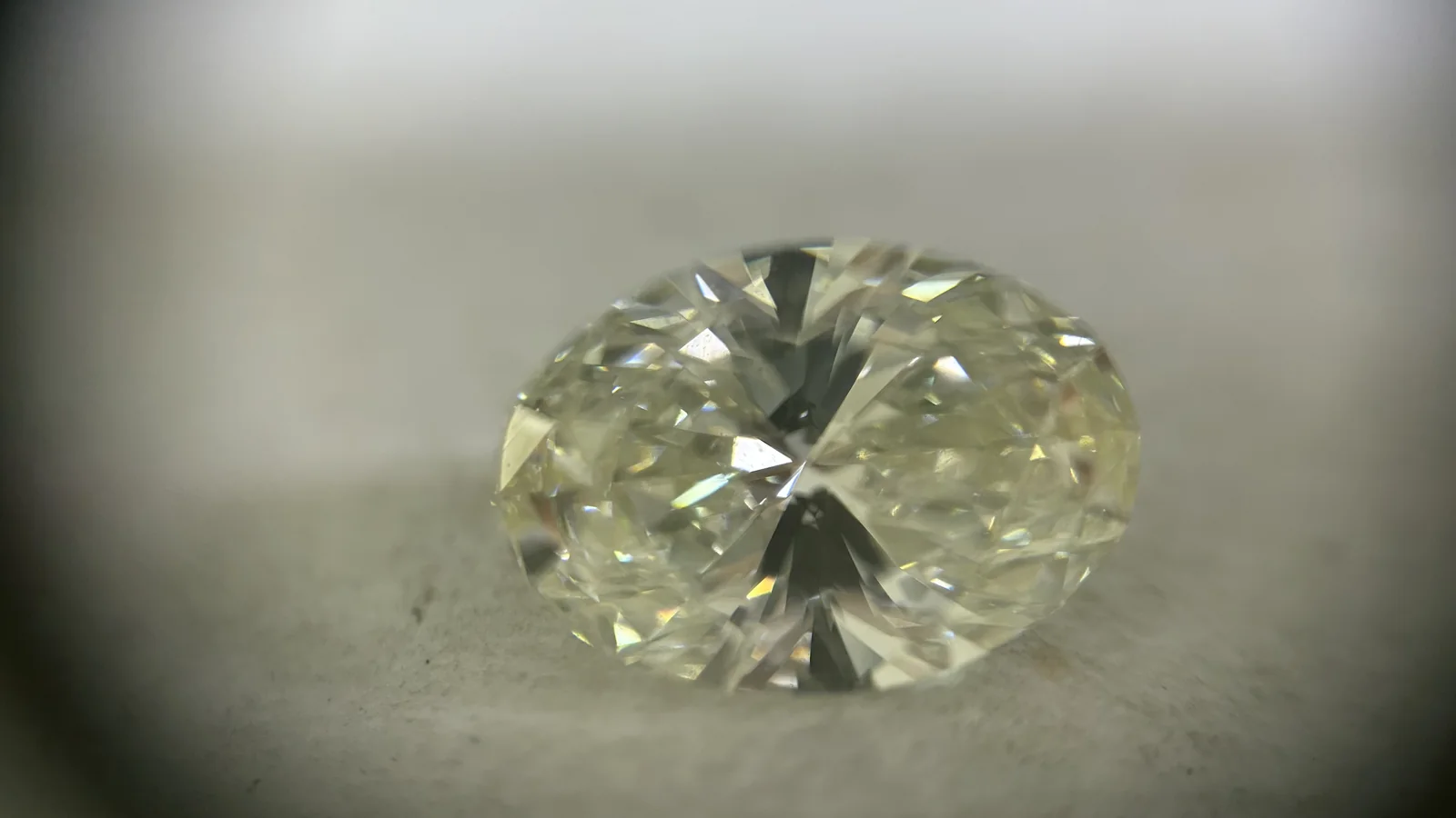 An oval diamond under a loupe on the grading desk